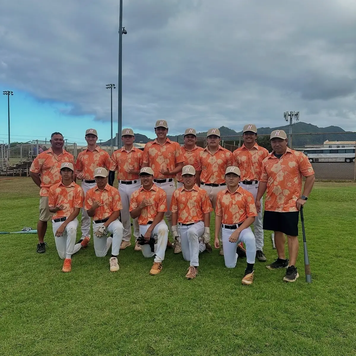 A baseball team in orange floral shirts on the field