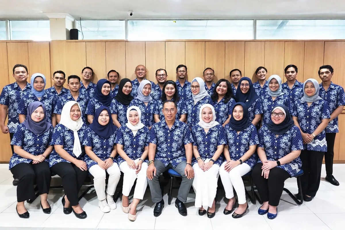 Office staff in matching blue batik-style shirts