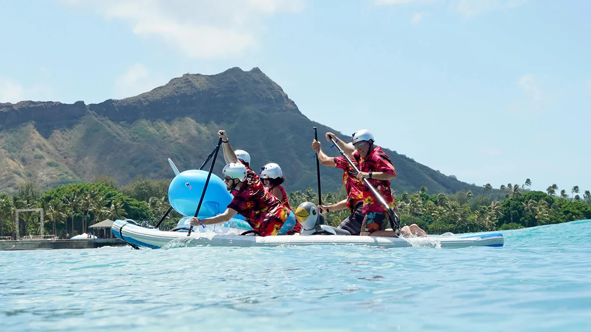 A paddle team in red aloha shirts on the water